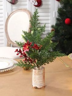 a vase filled with flowers sitting on top of a table next to a christmas tree