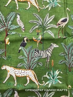 a green fabric with animals and birds on it