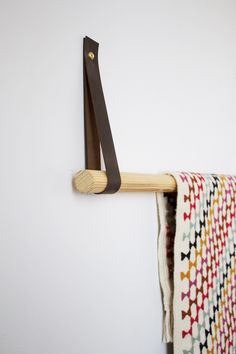 a pair of scissors hanging on the wall next to a towel rack with a wooden handle