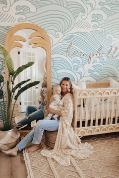 a woman sitting in front of a mirror holding a baby