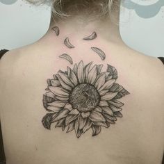 a woman with a sunflower tattoo on her back