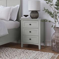 a white bed sitting next to a gray dresser