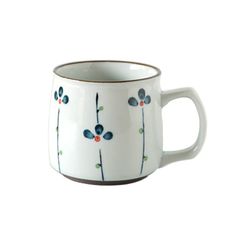 a white coffee cup with blue flowers and leaves on the rim, sitting against a white background