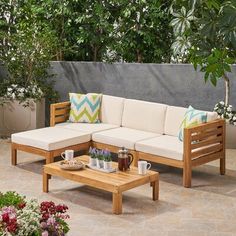 a blue couch sitting on top of a wooden table next to a planter filled with flowers