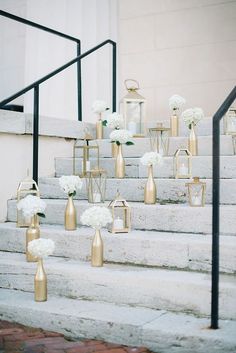 white flowers and gold vases are on the steps