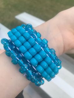 a person's arm with a blue beaded bracelet on it