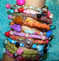 a woman's arm covered in lots of bracelets