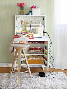 a sewing machine sitting on top of a wooden table next to a white shelf filled with books