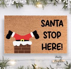 santa stop here door mat on white wooden background