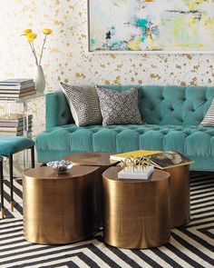 a living room with blue couches and gold accents on the walls, striped rugs