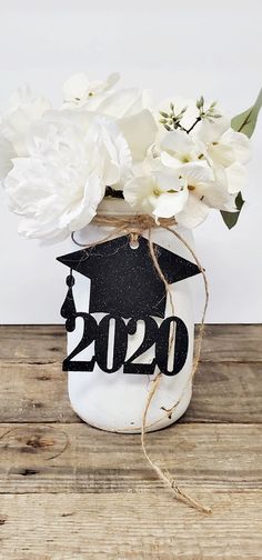 a mason jar filled with white flowers on top of a wooden table next to a wall