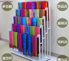 there are many different colored towels on the rack in front of the wall and below it is an advertisement with chinese characters