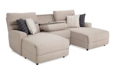 a beige sectional sofa with pillows on it