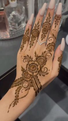 a woman's hand with henna tattoos on it