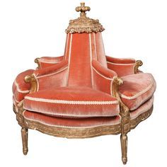 an orange chair with gold trimmings and a cross on the armrest, sitting in front of a white background