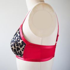 a female mannequin wearing a pink and black bra with leopard print on it