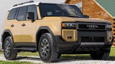 a yellow land rover parked in front of a log cabin on gravel road next to grass