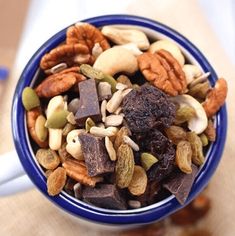 a blue bowl filled with nuts and chocolate