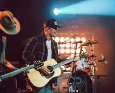 two men are playing guitars and singing on stage