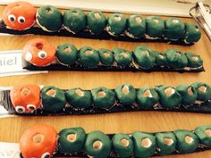 three green and orange doughnuts with googly eyes on them are sitting on a table