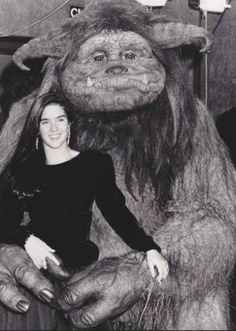 a woman standing next to a giant stuffed animal