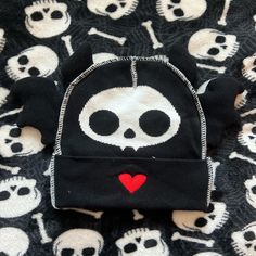 a black and white skull hat with red heart on it