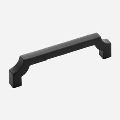 a black cabinet handle on a white wall