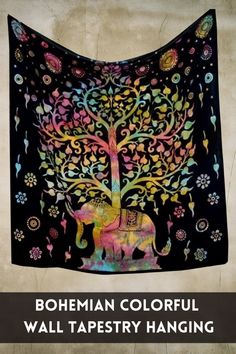 bohemian colorful wall tapestry hanging with an elephant and tree in the center, on a black background