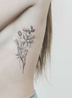 a black and white photo of a flower on the side of a woman's stomach