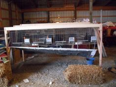 an animal cage with hay in it and some other things on the ground around it