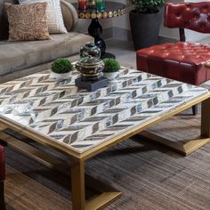 a living room with couches, chairs and a coffee table in the middle of it