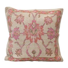 an embroidered pillow with pink flowers and leaves on the front, against a white background