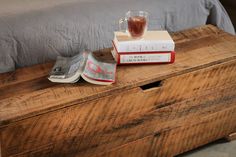 a bed with a book and cup on top of it