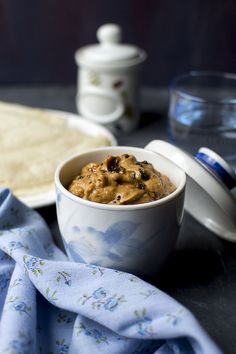 a bowl filled with food sitting on top of a table next to a blue towel