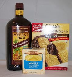 ingredients to make chocolate cake on a white tablecloth with a bottle of syrup and two packets of cookies