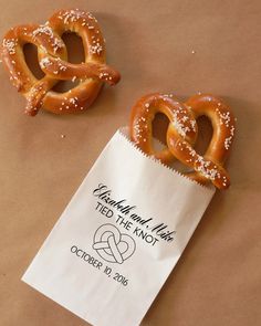 two pretzels sitting on top of a brown paper bag next to each other