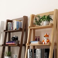 two wooden ladders with books on them in front of a book shelf filled with books