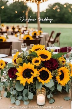 sunflowers and greenery are arranged on the table at this outdoor wedding reception