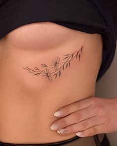 a close up of a person's stomach with flowers on the side and behind her