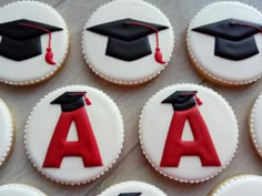 decorated cookies with graduation caps and tassels are arranged on a table in rows