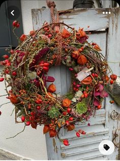 an old door with a wreath and bird on the front, hanging from it's side