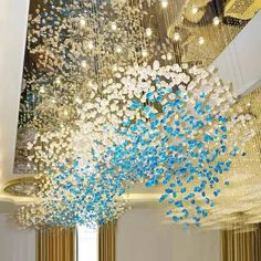 a large chandelier with blue and white flowers hanging from it's ceiling