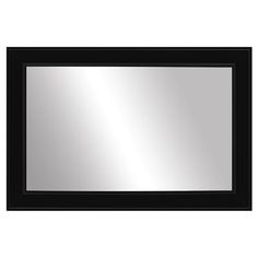 a black framed mirror on a white wall