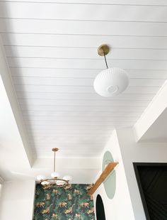 the ceiling is painted white and has green wallpaper on it, along with an animal print rug