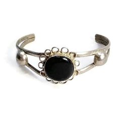 Vintage , Adjustable, Mexico Sterling Silver and Onyx Cuff Bracelet. Delicate, feminine flower design. DETAILS:  ☼ Acid Tested Sterling Silver. ☼ Adjustable cuff bracelet. ☼ Typical Southwestern Design.   ☼ Black Stone. ☼ Approximately 5 inches long (inside cuff), 1 1/4 inches wide.  ☼ Approximately 14 grams, total weight. ☼ Slightly tarnished.   ☼ ☼ ☼ ☼ ☼ ☼ ☼ ☼ ☼ ☼ ☼ ☼ ☼ ☼ ☼ ☼ ☼ ☼ ☼ ☼ ☼ PLEASE NOTE:  ☼ Different items on SALE everyday!  Check back often to take advantage of these bargains! ☼ FREE DOMESTIC SHIPPING on purchases of $35 or more. Combined shipping is still available to domestic and international locations. ☼ This shop is happy to accept exchanges, returns for store credit.  Cash returns are only available in the rare event that an item is inaccurately described.  For example, Southwestern Design, Black Stone, Favorite Pins, Alpaca, Cuff Bracelet, Flower Designs, Onyx, Cuff Bracelets, Jewelry Bracelets