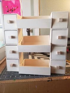 there is a doll house made out of cardboard and drawers on top of the table