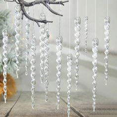 a group of crystal beads hanging from a tree branch in front of a christmas tree