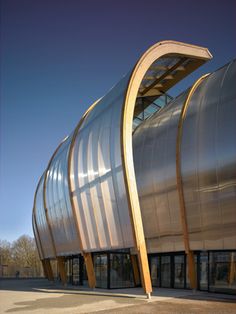 the curved building is made out of metal and wood