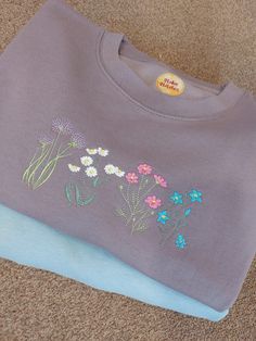 This cosy wildflower jumper is dusty lilac in colour (other colours also available). It features 4 beautifully embroidered images of a flowers perfect for those spring days or gardening enthusiasts. The jumper is professionally embroidered by myself in my home studio in Staffordshire. The jumpers are a unisex fit, please check the size guide if unsure If it helps I am a size 12 and wear a Medium Lavender Crew Neck Sweatshirt For Fall, Lavender Cotton Crew Neck Sweatshirt, Spring Lavender Crew Neck Sweatshirt, Lavender Crew Neck Sweatshirt For Spring, Flower Jumper, Embroidered Jumper, Dusty Lilac, Summer Sweatshirt, Spring Sweater