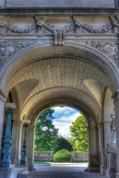 an archway leading into a lush green park